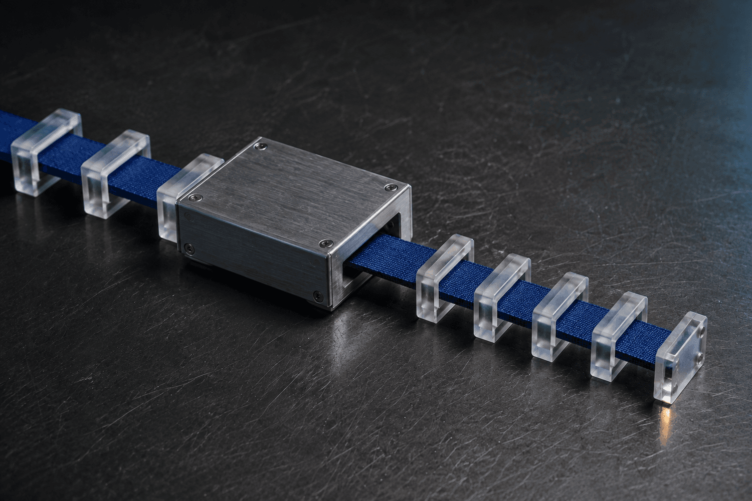 Cobalt ribbon passing through a metal gateway, with wider frames before it and shorter frames after it.